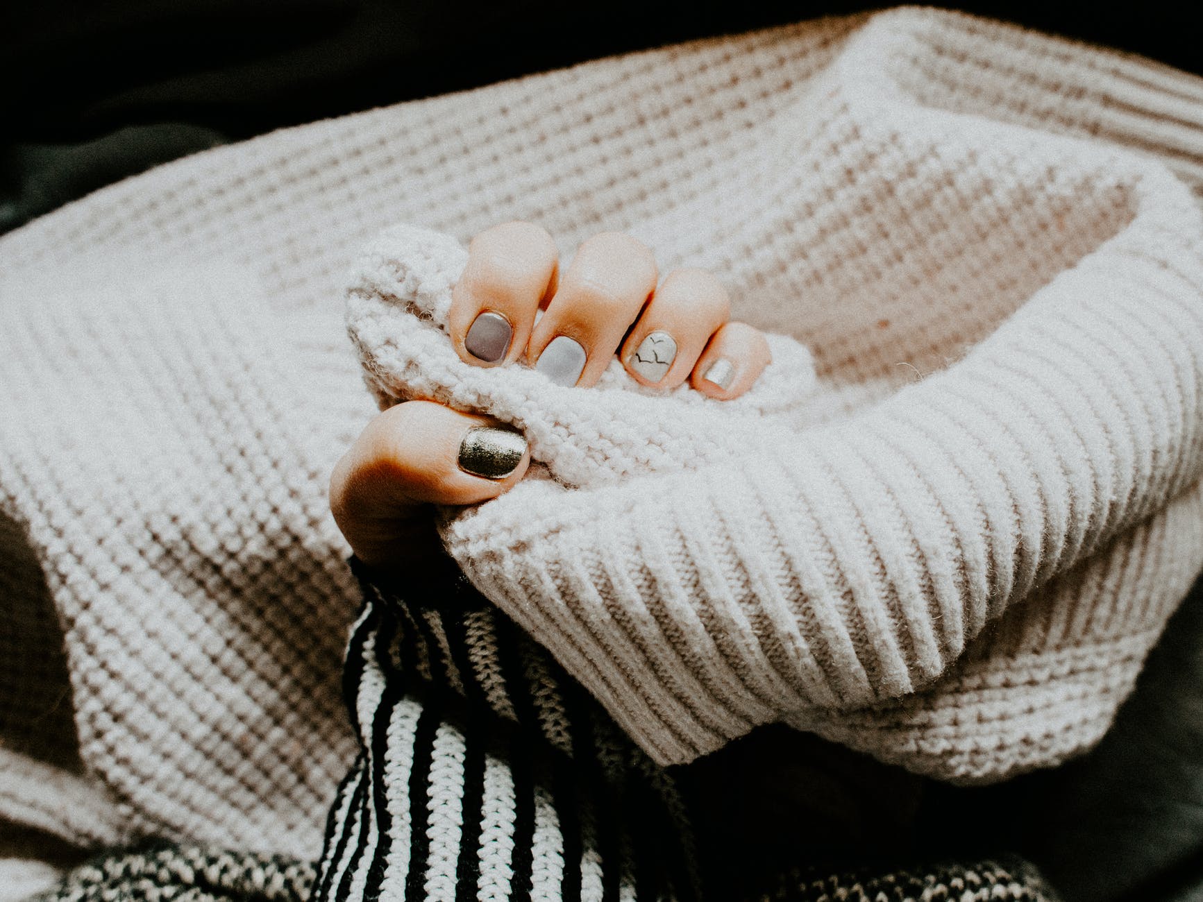 person holding coat with manicured nails