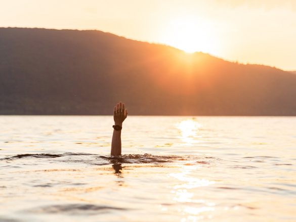 person under water raising hand