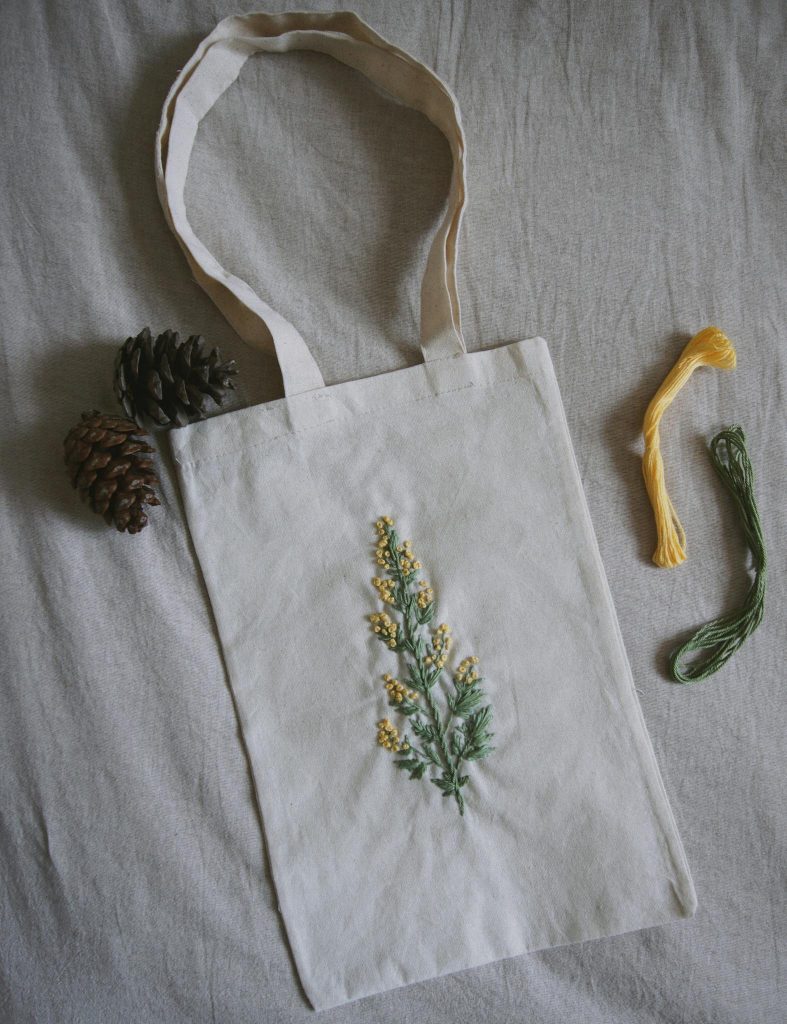 Elegant cotton tote bag with handcrafted floral embroidery, ideal for eco-friendly shopping.