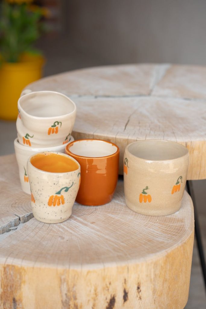 handcrafted ceramic mugs on rustic wood table